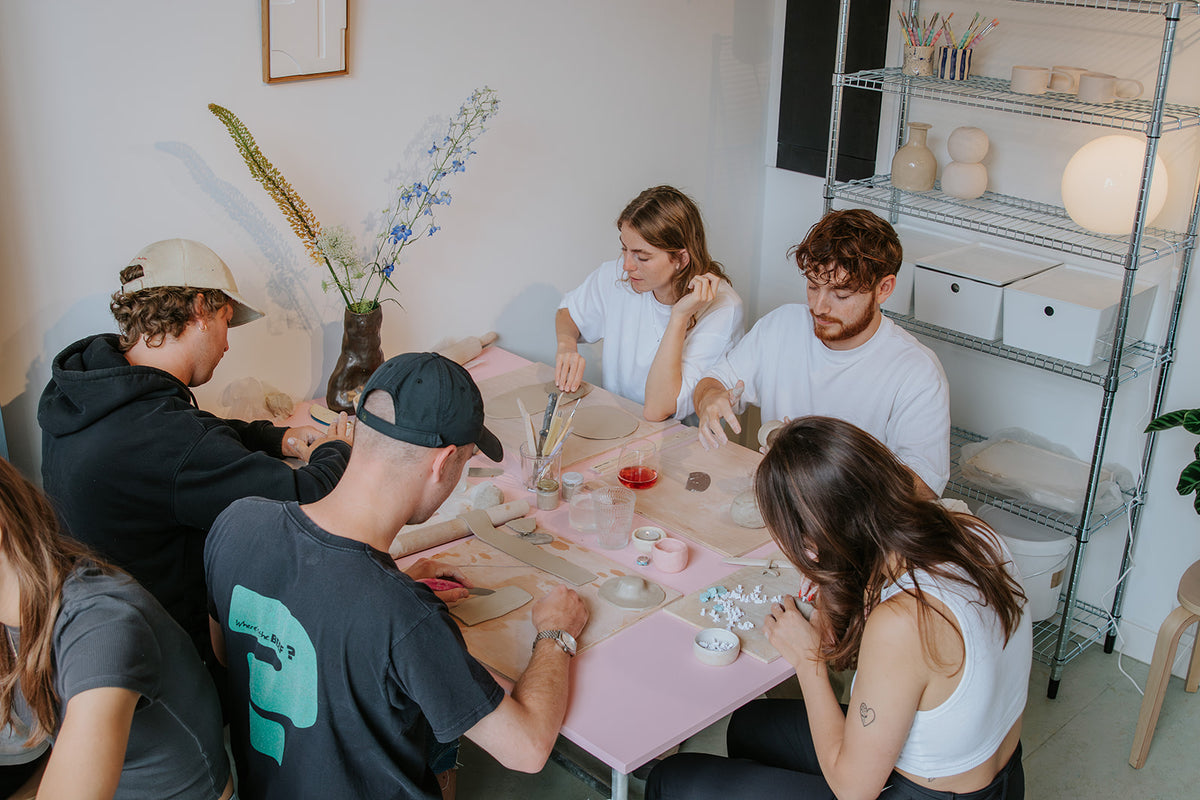 Groep vrienden aan het kleien tijdens een workshop bij Comes Good in Amsterdam