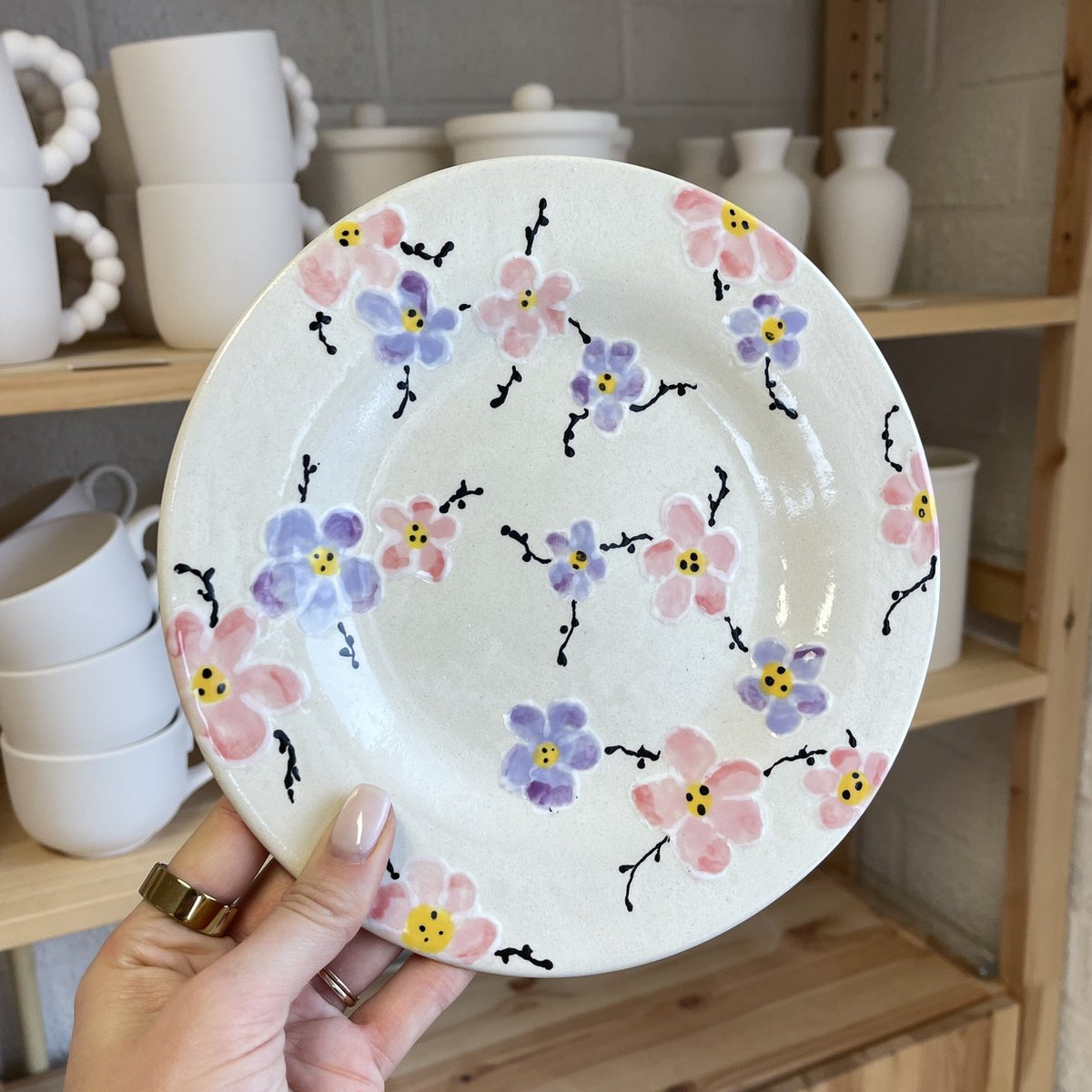 Zelf beschilderd bord met roze en blauwe bloemetjes